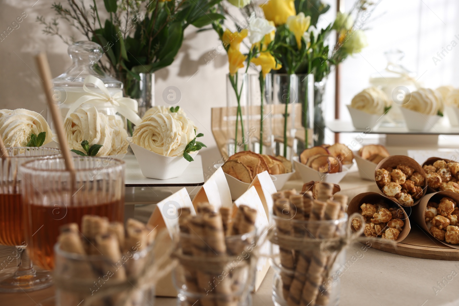 Photo of Tasty treats and glasses of drink on table. Sweet buffet