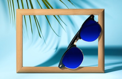 Image of New stylish elegant sunglasses with blue lenses on blue background