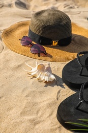 Set with stylish beach accessories on sand