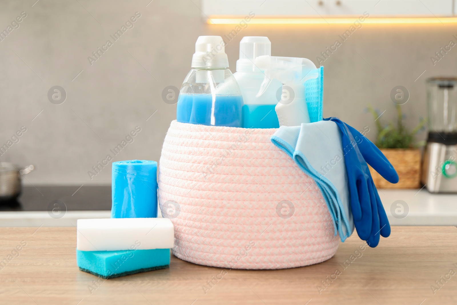 Photo of Different cleaning supplies in basket on table