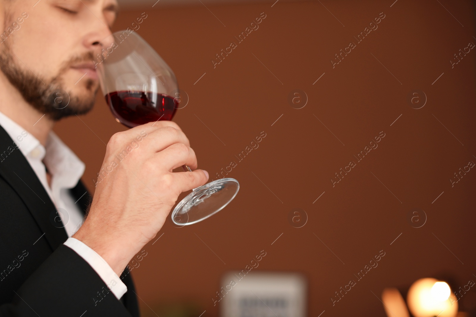 Photo of Young man with glass of wine indoors