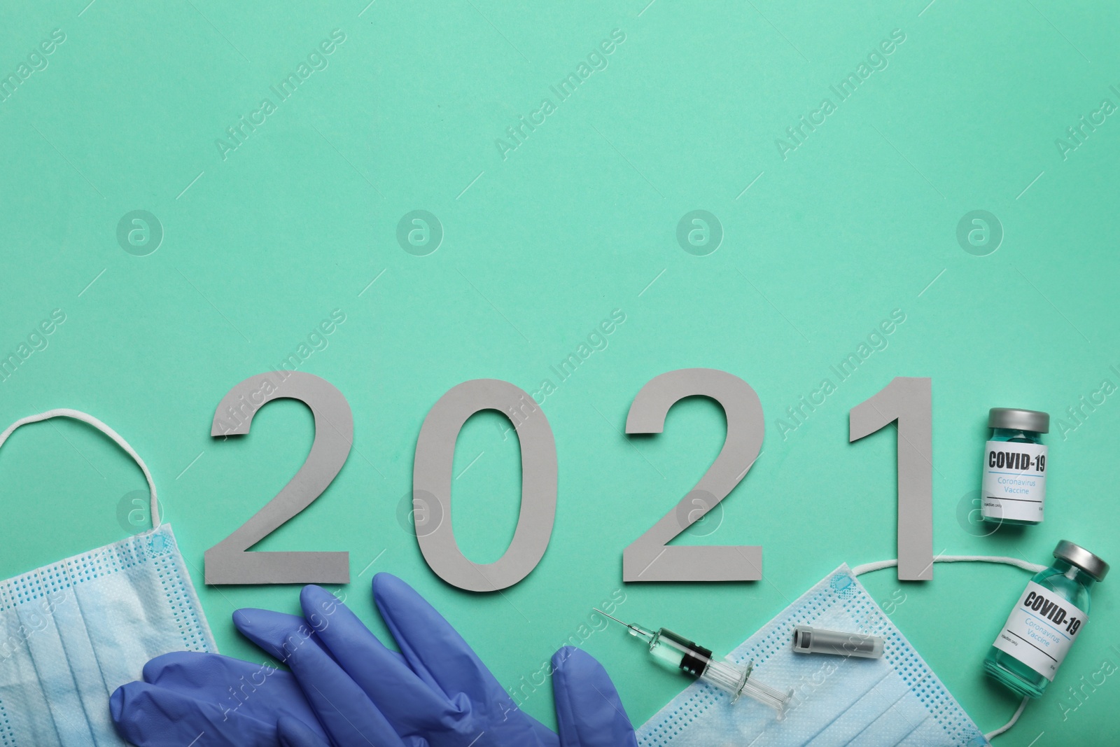 Photo of Flat lay composition with coronavirus vaccine and number 2021 on turquoise background. Space for text