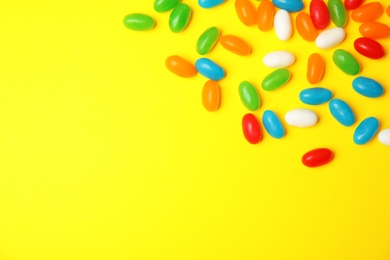 Photo of Flat lay composition with jelly beans on color background. Space for text