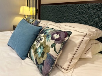 Photo of Large bed with soft pillows in hotel room