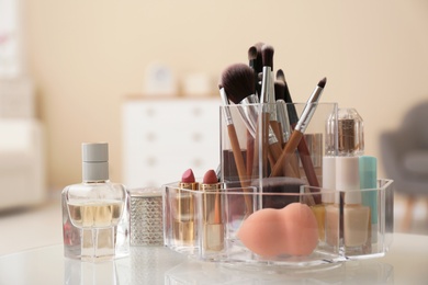 Photo of Organizer with cosmetic products for makeup on table indoors