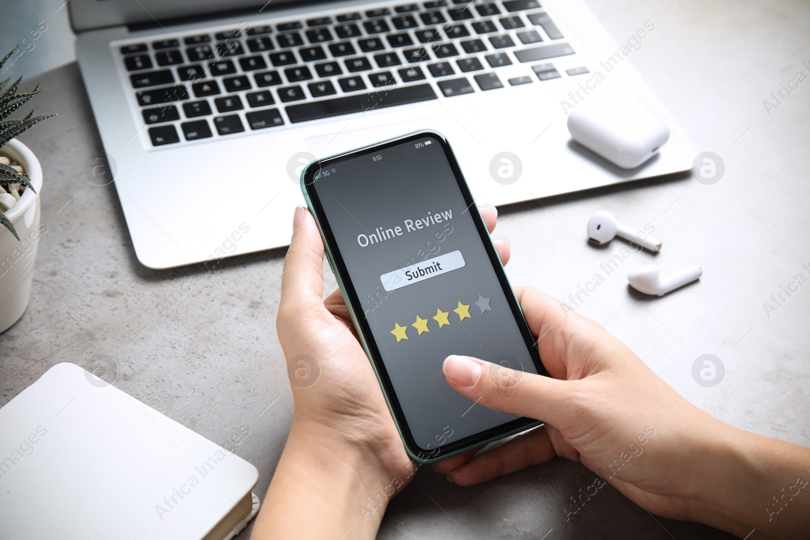 Image of Woman using smartphone to give feedback at table, closeup. Customer review