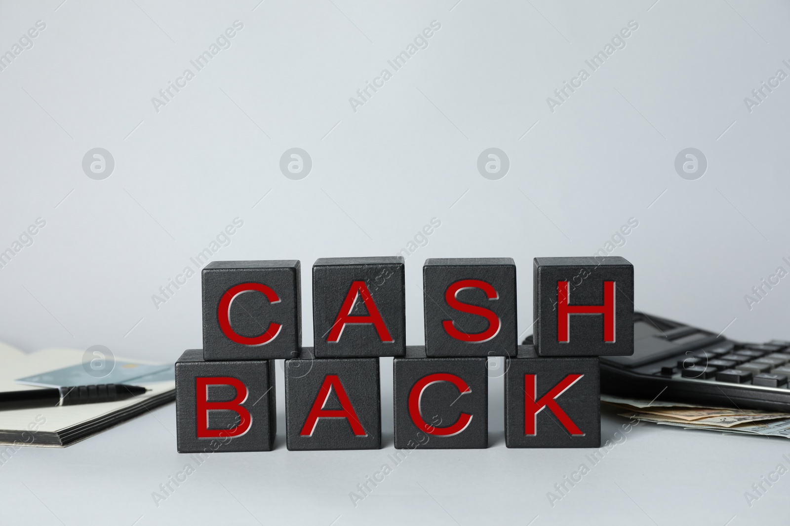 Photo of Word Cashback made with cubes, money and calculator on grey background