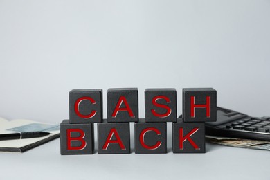 Photo of Word Cashback made with cubes, money and calculator on grey background