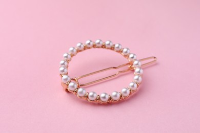 Photo of Elegant pearl hair clip on pink background