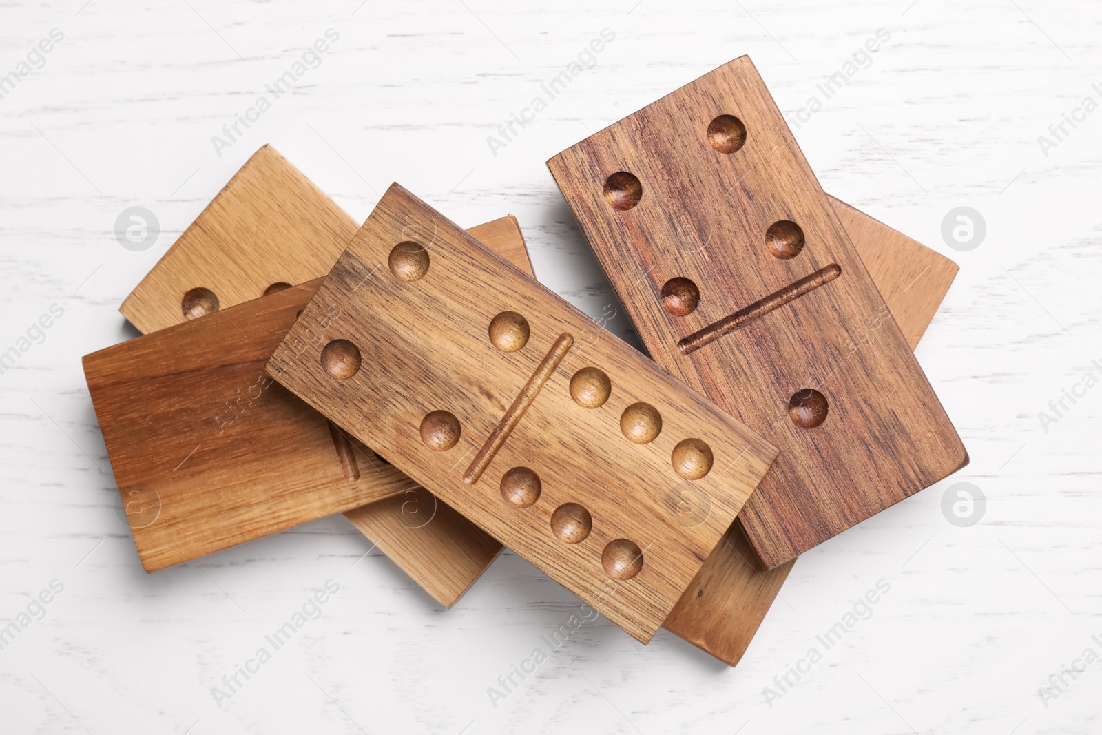 Photo of Domino tiles on white wooden table, flat lay