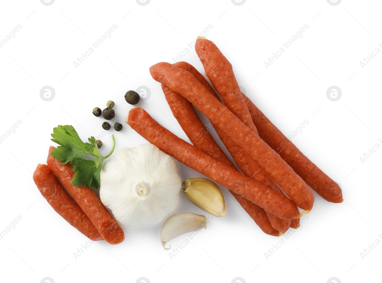 Photo of Thin dry smoked sausages and different spices isolated on white, top view