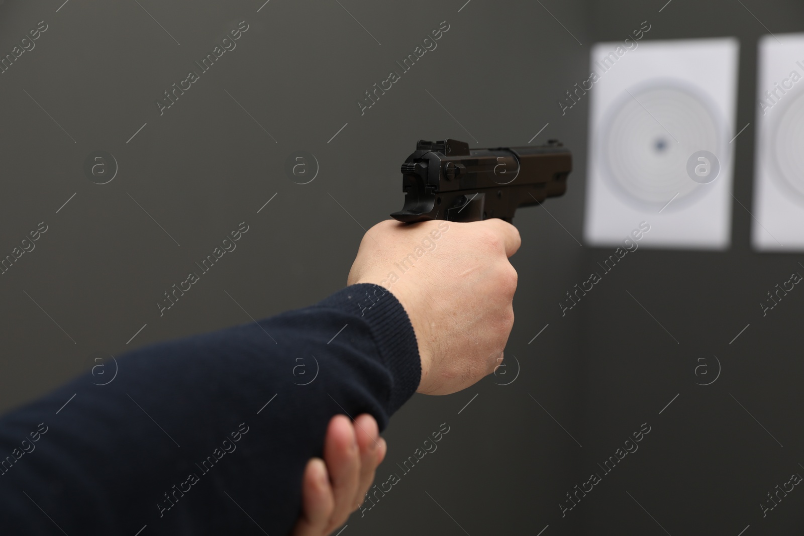 Photo of Man aiming at shooting target indoors, closeup