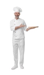 Photo of Happy chef in uniform pointing at wooden board on white background