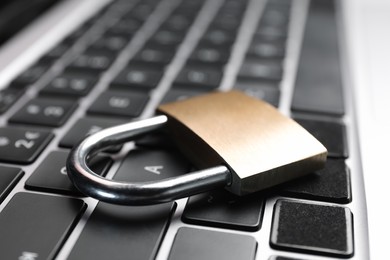 Photo of Cyber security. Metal padlock on laptop, closeup