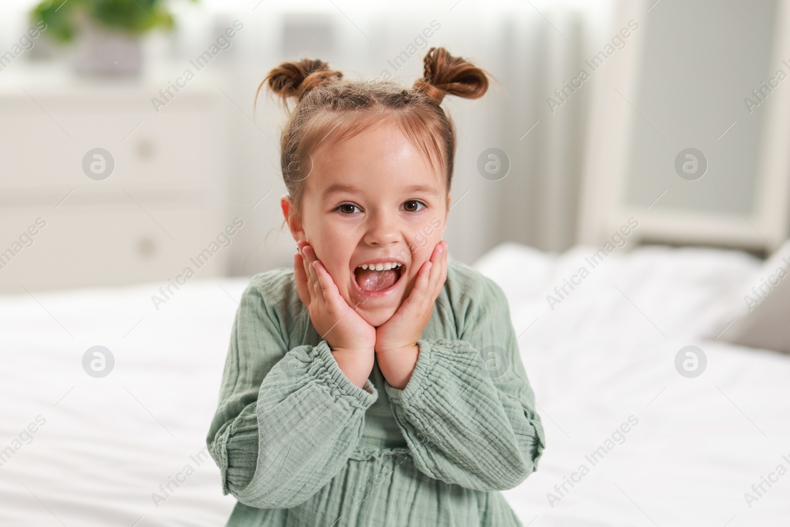 Photo of Portrait of emotional little girl in bedroom
