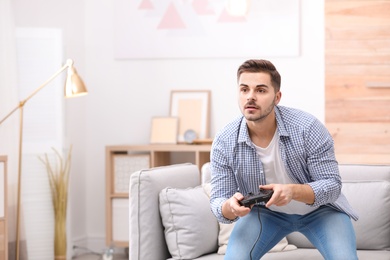 Emotional young man playing video games at home