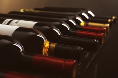 Bottles with delicious wine on shelf, closeup. Professional sommelier