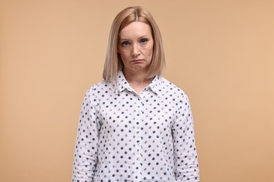 Photo of Portrait of sad woman on beige background