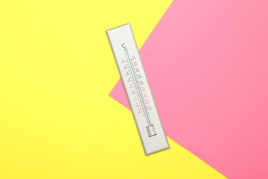 Weather thermometer on color background, top view