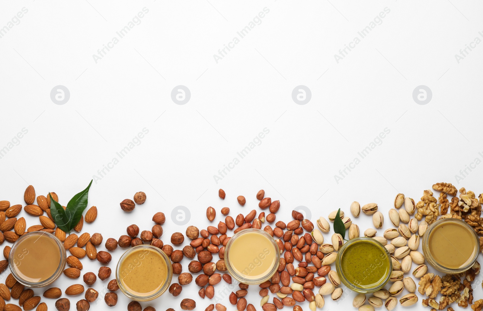 Photo of Different types of delicious nut butters and ingredients on white background, top view