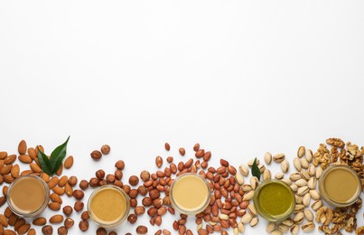 Different types of delicious nut butters and ingredients on white background, top view