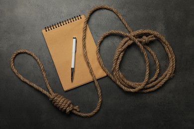 Rope noose and blank notebook with pen on grey table, flat lay