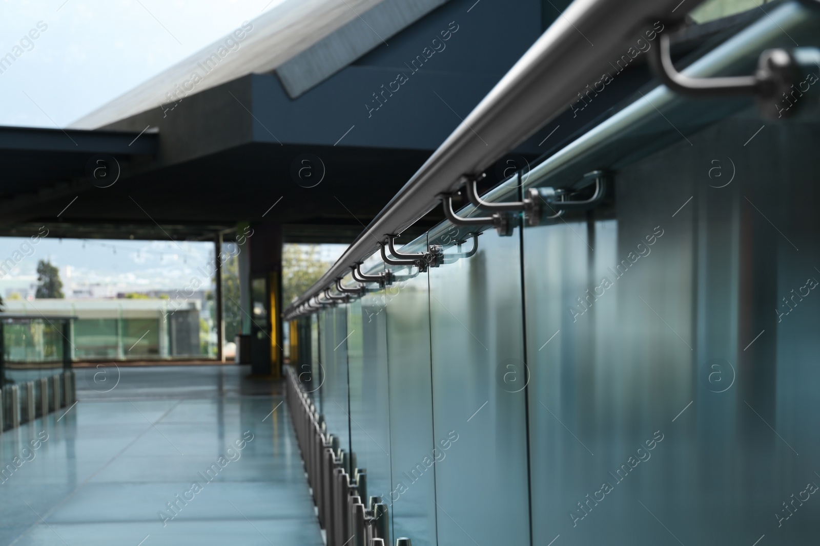 Photo of Glass barrier with metal handrail in modern building, closeup