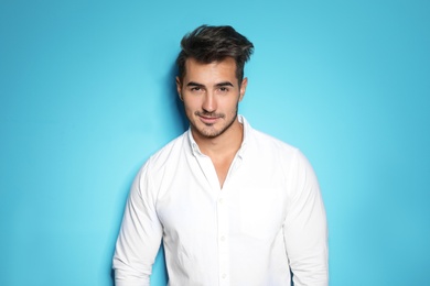 Photo of Young man with trendy hairstyle posing on color background