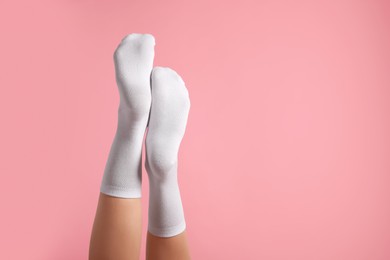 Photo of Woman in stylish white socks on pink background, closeup. Space for text