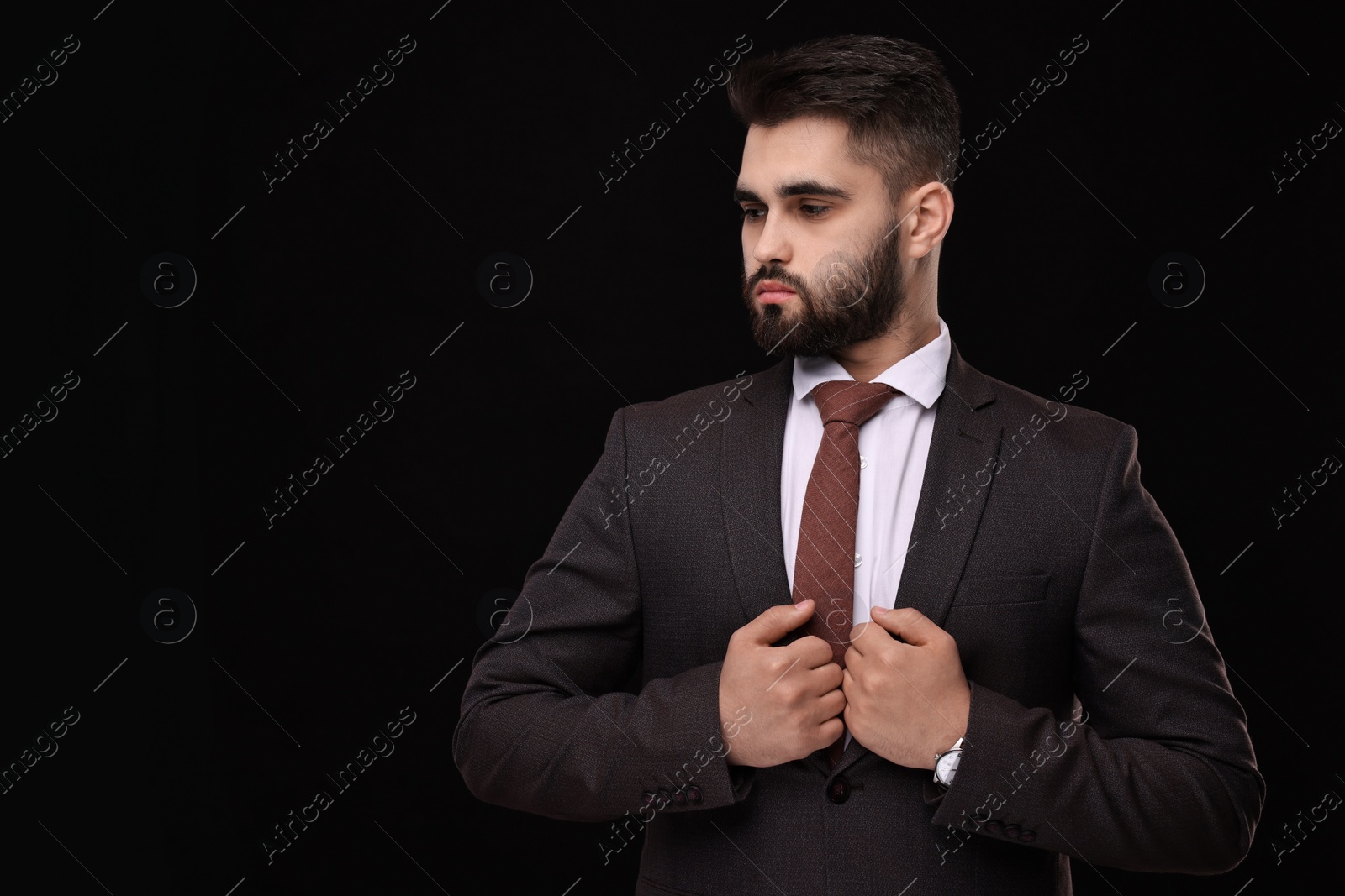 Photo of Handsome businessman in suit and necktie on black background. Space for text