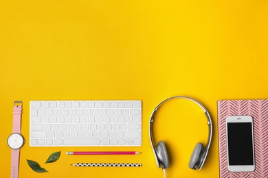 Photo of Flat lay composition with smartphone, computer keyboard, headphones and space for text on color background