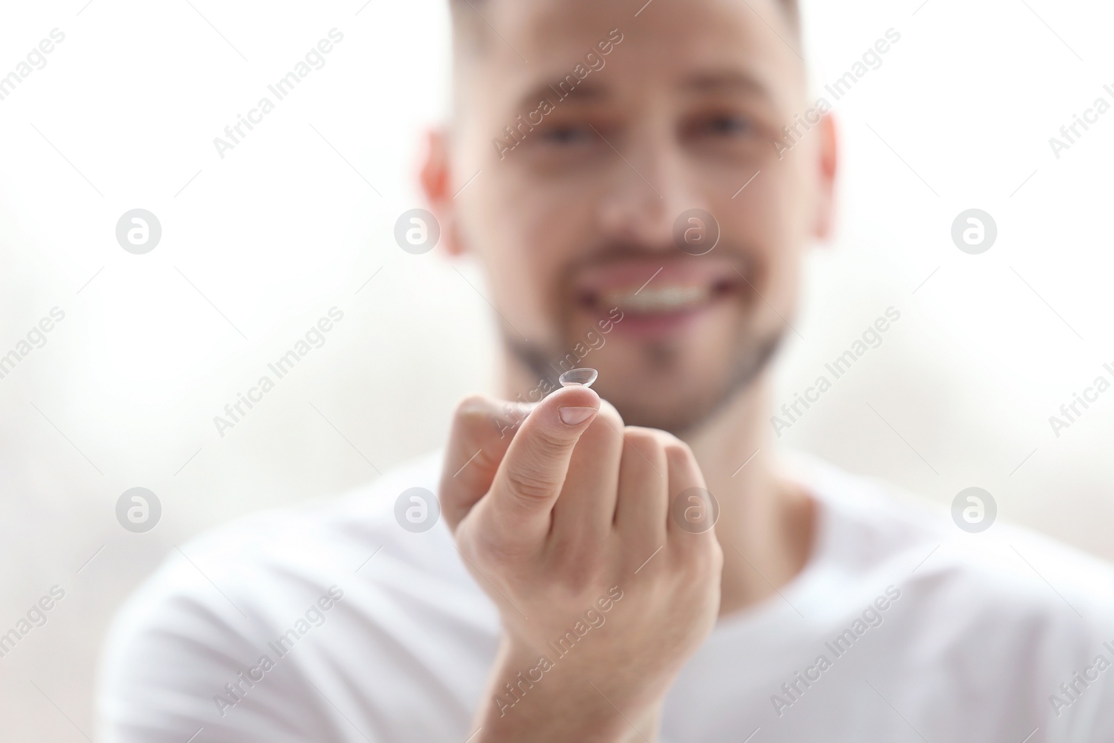 Photo of Man holding contact lens, closeup