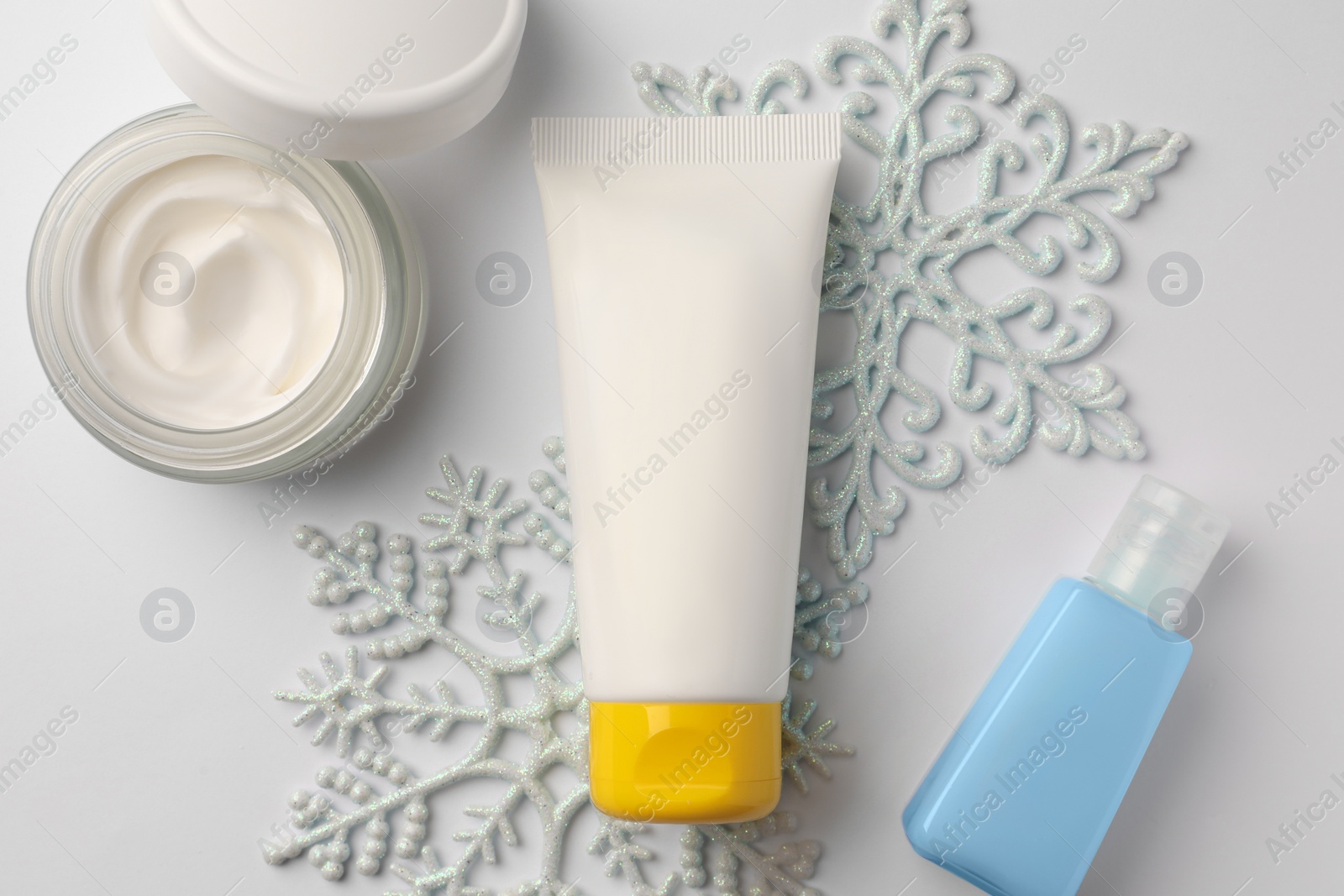 Photo of Winter skin care. Flat lay composition with hand cream and cosmetic products on white background