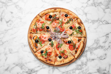 Photo of Tasty pizza with seafood on white marble table, top view