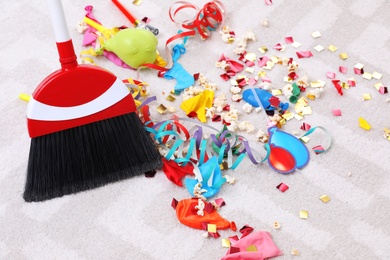 Photo of Sweeping trash after party with bristle broom indoors