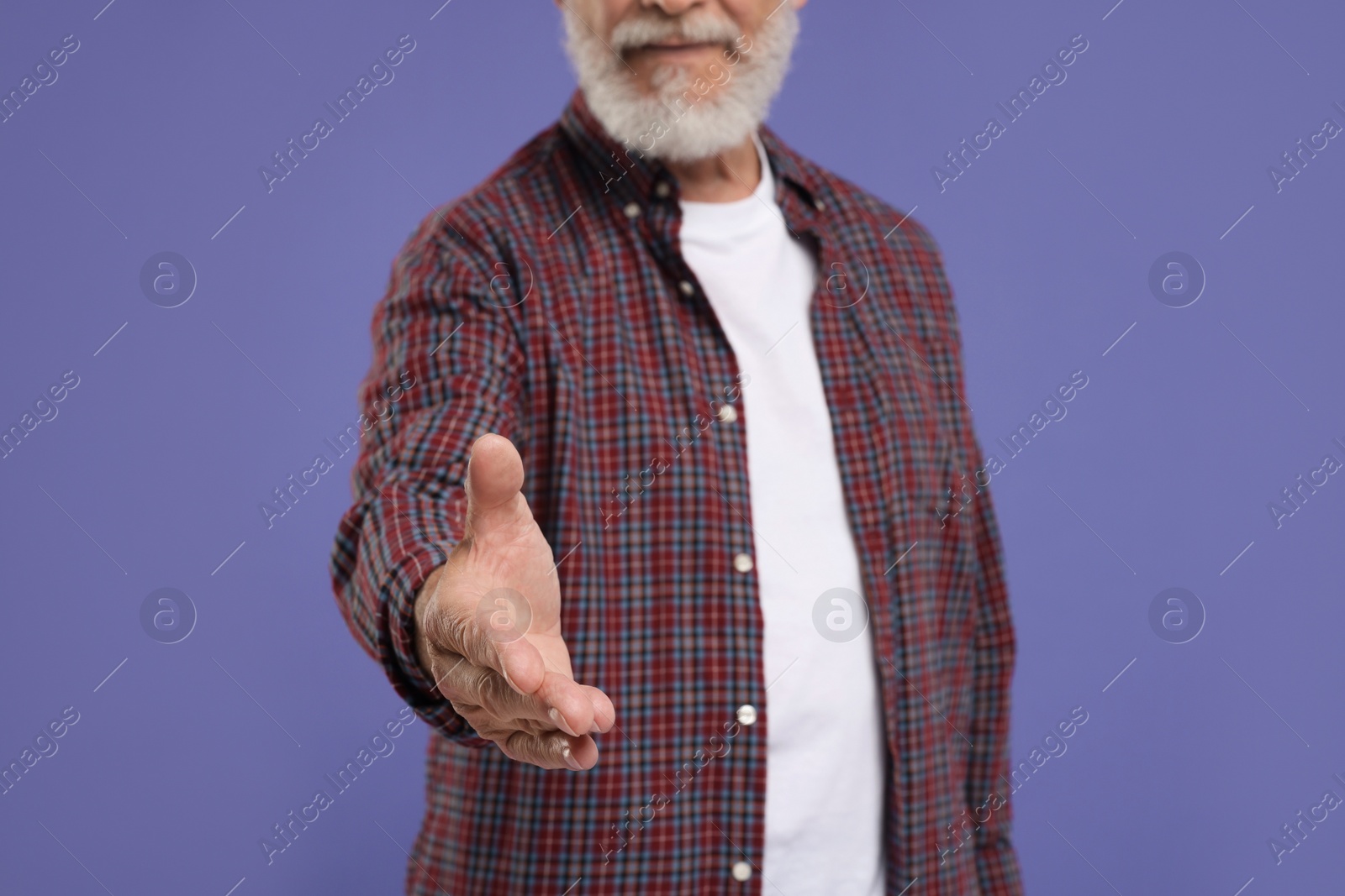 Photo of Man welcoming and offering handshake on purple background, closeup