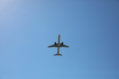 Photo of Modern white airplane flying in sky, bottom view
