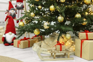Photo of Beautiful Christmas tree and many gift boxes in room