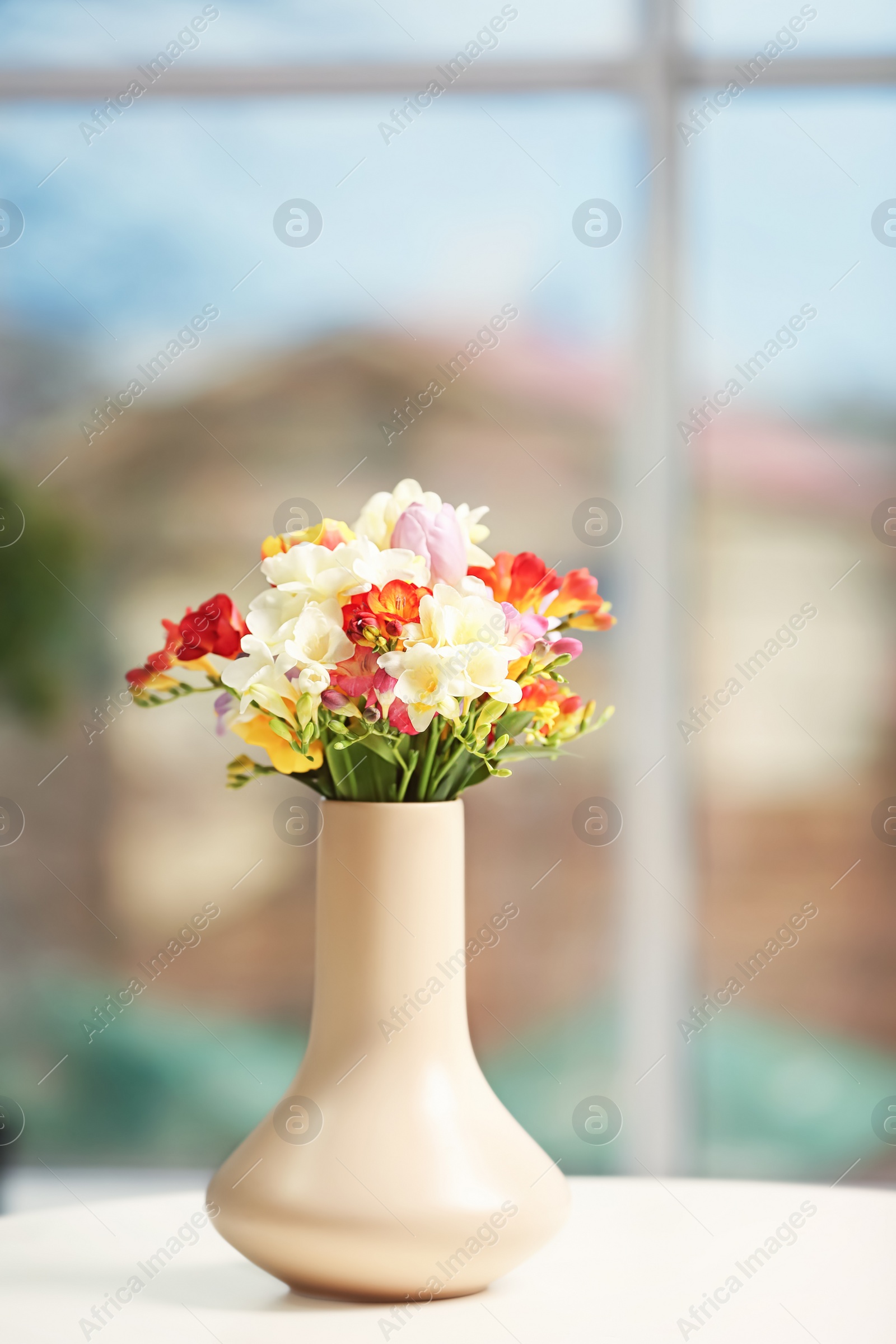 Photo of Beautiful bouquet of freesia flowers indoors