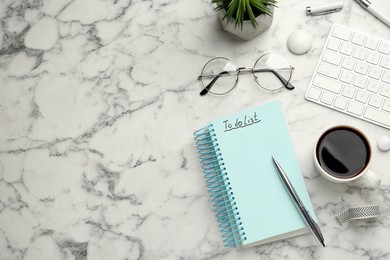 Flat lay composition with unfilled To Do list and cup of coffee on white marble table, space for text