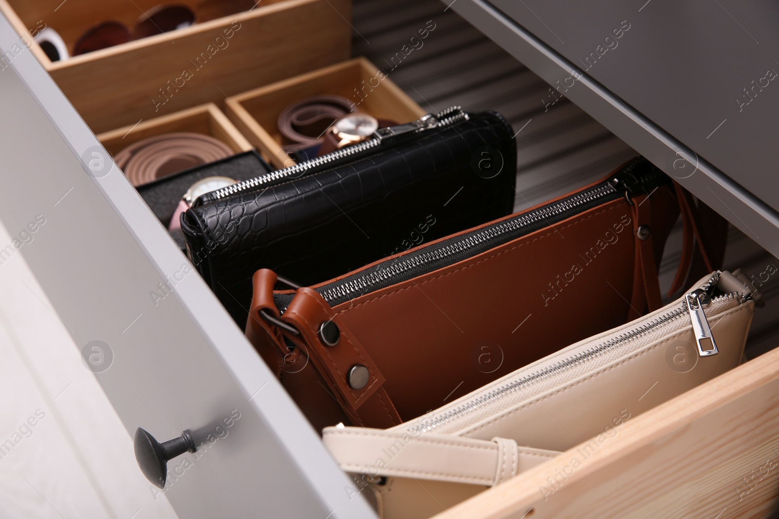 Photo of Open drawer with different stylish accessories indoors, closeup. Storage and organizing