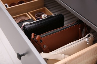 Open drawer with different stylish accessories indoors, closeup. Storage and organizing