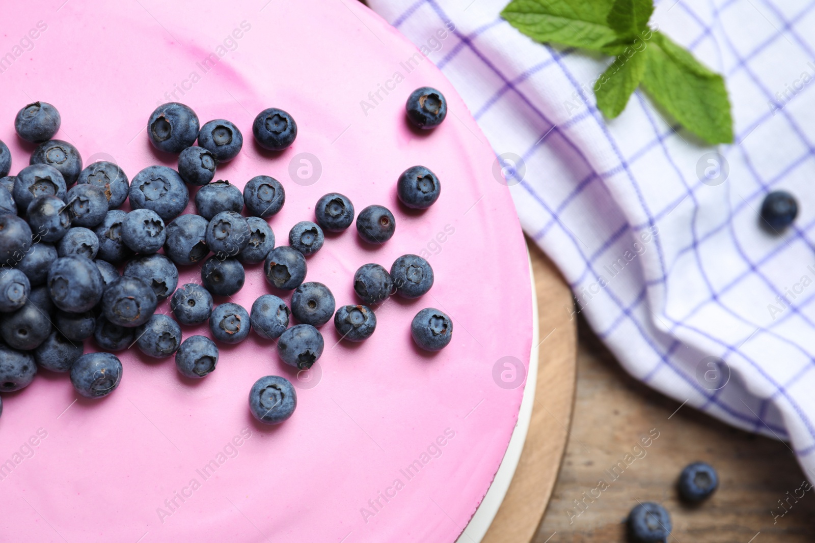 Photo of Board with tasty blueberry cake on wooden table, closeup