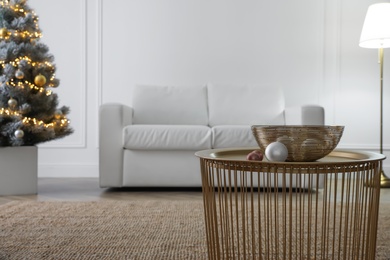 Photo of Christmas ornaments and bowl on table in living room. Interior design