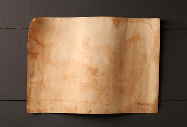 Sheet of old parchment paper on grey wooden table, top view
