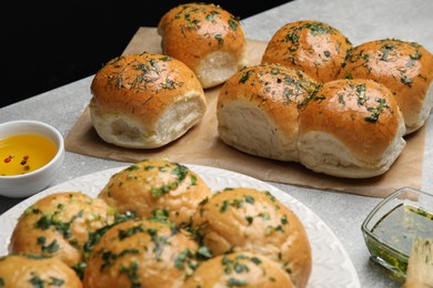 Traditional pampushka buns with garlic and herbs on grey table