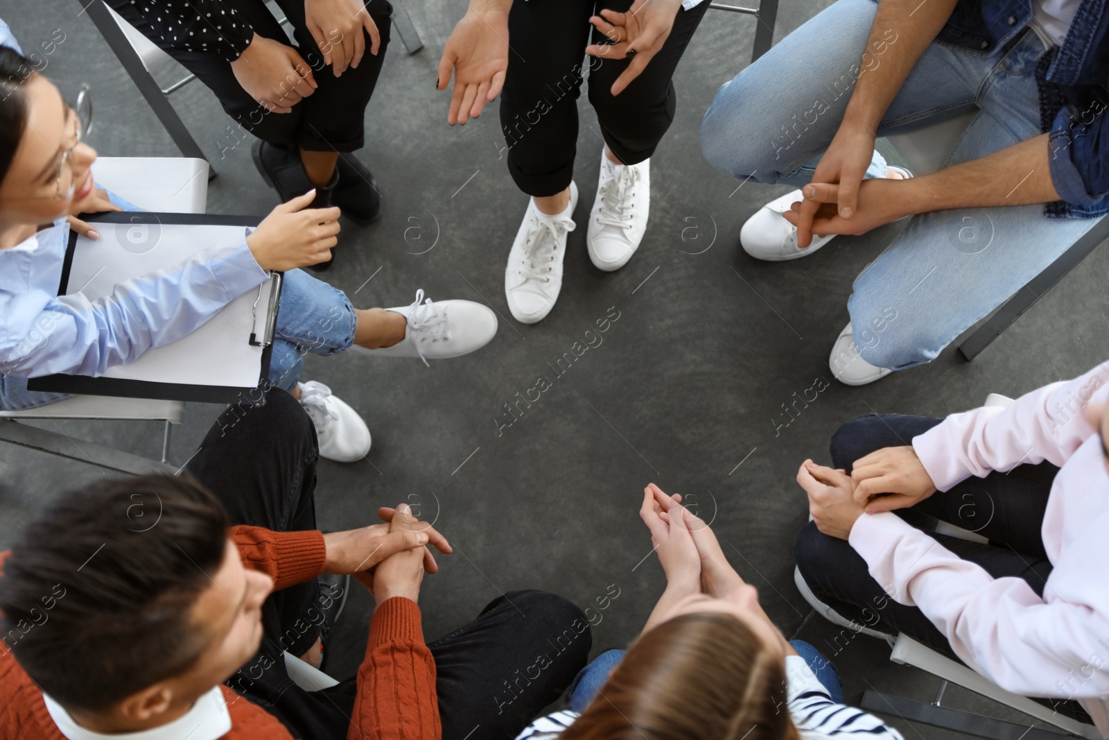 Photo of Psychotherapist working with patients in group therapy session, top view