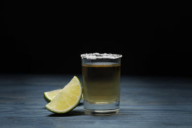 Photo of Mexican Tequila shot with salt and lime on blue wooden table