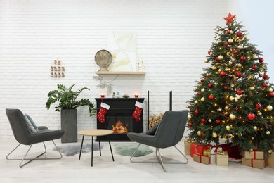Beautiful Christmas tree near fireplace and cosy armchairs in room. Interior design