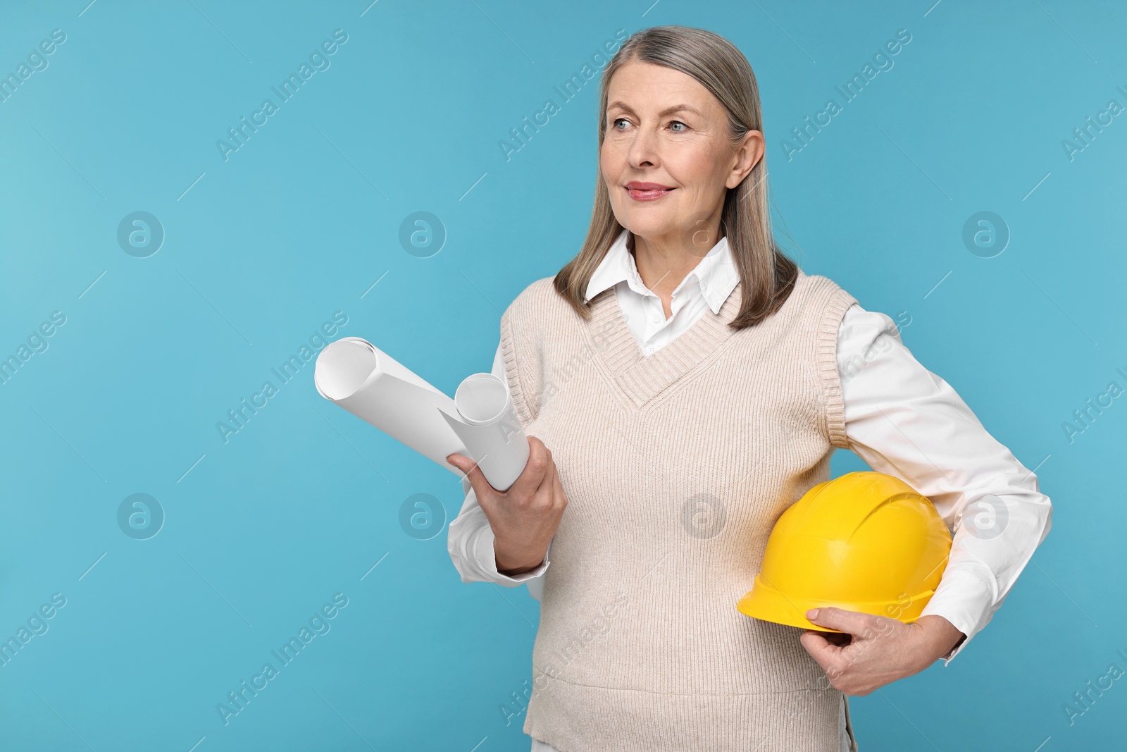 Photo of Architect with hard hat and drafts on light blue background, space for text